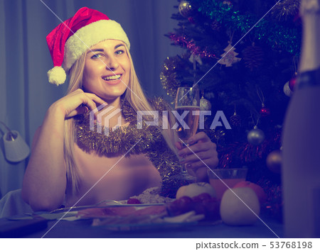 Young woman is sitting with champagne in New Year night Young woman is sitting with champagne in New Year night 53768198