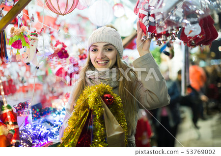 woman shopping at Christmas fair before Xmas in evening time woman shopping at Christmas fair before Xmas in evening time 53769002
