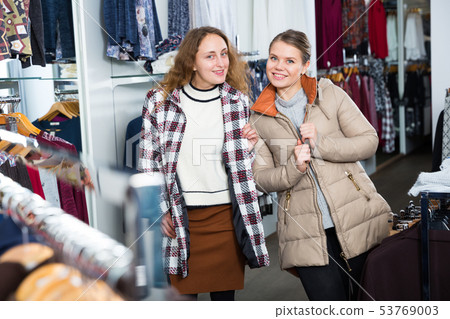 Female friends posing in new coat Female friends posing in new coat 53769003