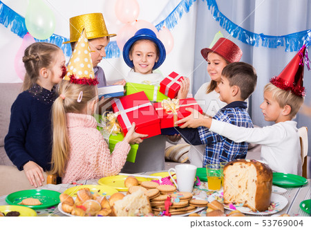 happy children giving presents to girl during party happy children giving presents to girl during party 53769004