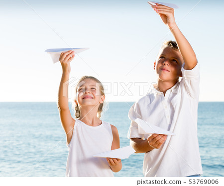 boy and girl playing origami planes boy and girl playing origami planes 53769006