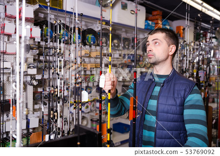 male choosing fishing rod male choosing fishing rod 53769092