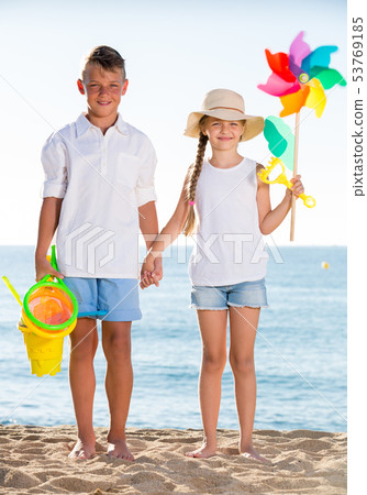 boy and girl standing beach toys 53769185