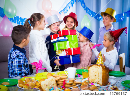 glad children giving presents to girl during party glad children giving presents to girl during party 53769187