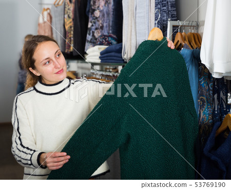 Female customer choosing new coat Female customer choosing new coat 53769190