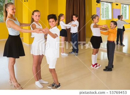 Teacher is showing to children how to dance waltz Teacher is showing to children how to dance waltz 53769453