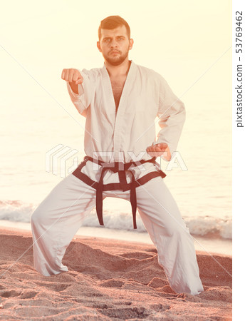 guy practising aikido poses at seaside 53769462