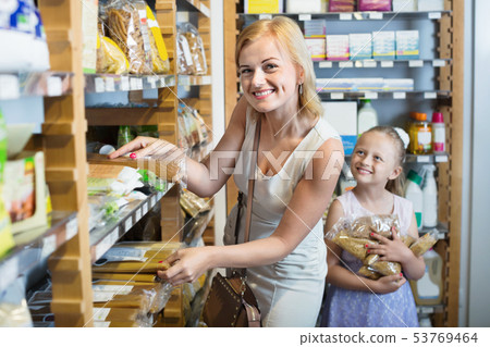 Portrait of woman and girl gladly shopping of pasta Portrait of woman and girl gladly shopping of pasta 53769464