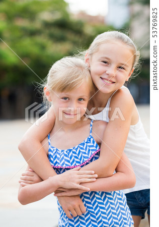 Two small happy sisters outdoors 53769825