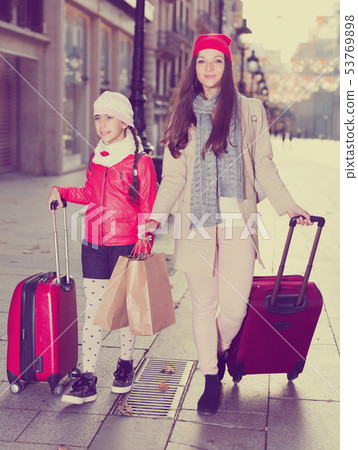woman with daughter walking with bags 53769898