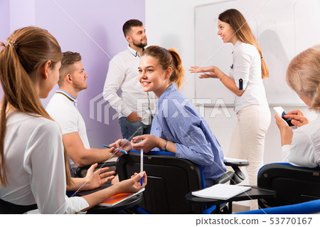 Group of students with teacher in break between lessons indoors 53770167