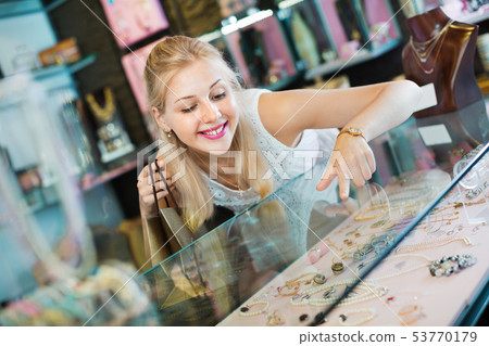 Portrait of young woman standing next to glass showcases 53770179
