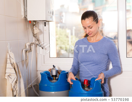 Woman setting up gas boiler 53770198