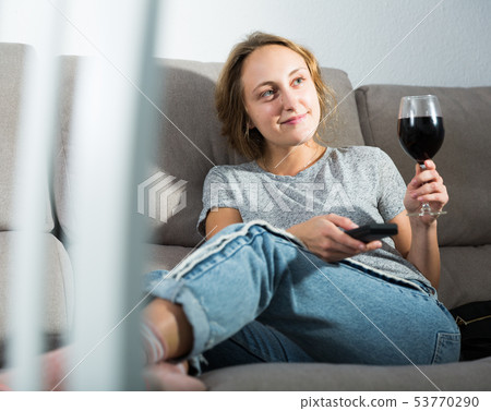 Woman relaxing at home watching TV Woman relaxing at home watching TV 53770290