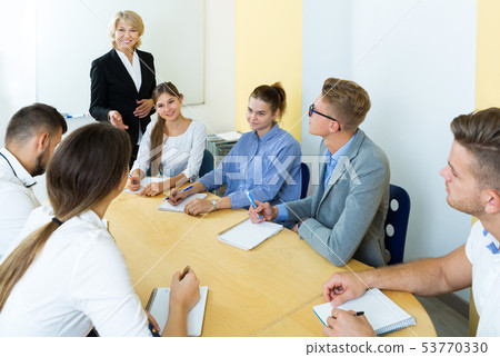 group of students listening teacher 53770330