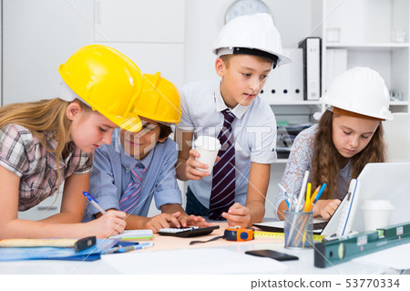 Children in helmet talking about building 53770334