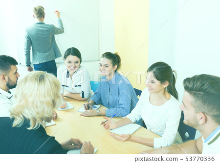 Group of smiling students brainstorming in classroom 53770336