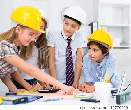 Teens engineers discussing draft at the table 53770339