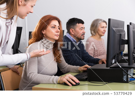 Focused mature woman taking computer lessons 53770429