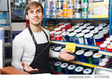Salesman offering enamel in store. 53770590
