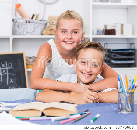 Sister is helping brother with homework Sister is helping brother with homework 53770698