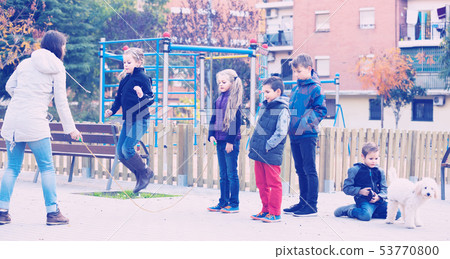 Children playing rubber band jumping game and laughing Children playing rubber band jumping game and laughing 53770800