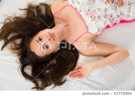 Top view of woman with flowing hair posing in bed in bedroom Top view of woman with flowing hair posing in bed in bedroom 53770864