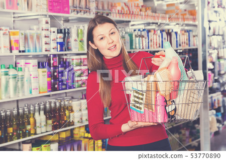 Young woman is standing with purchases in hair care store. Young woman is standing with purchases in hair care store. 53770890
