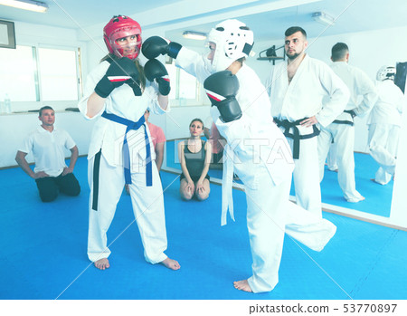 Adult girls are sparring in pair to use taekwondo technique 53770897