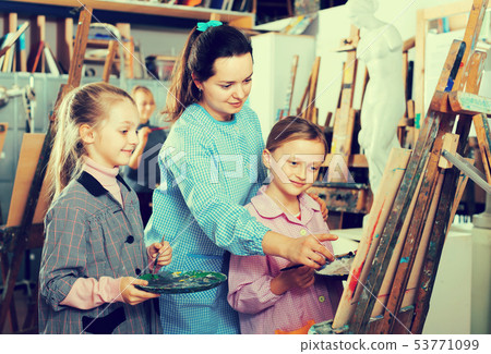 Teacher helping teenage students 53771099