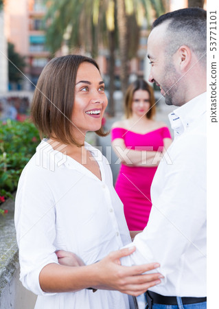 Cheerful couple are talking and woman is envying them Cheerful couple are talking and woman is envying them 53771101