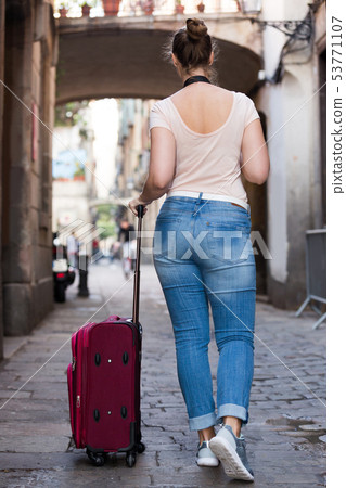 Smiling female tourist is walking Smiling female tourist is walking 53771107