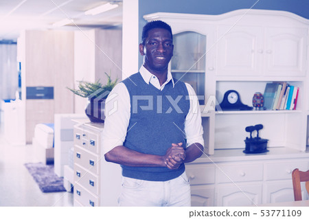 Portrait of smiling salesman who is offering modern furniture Portrait of smiling salesman who is offering modern furniture 53771109