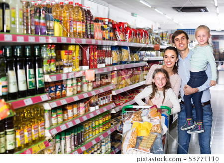 Couple with children buying food in hypermarket. Couple with children buying food in hypermarket. 53771110