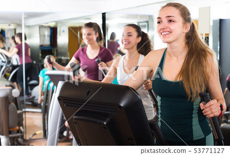 Women using cross-trainers in sport club . 53771127