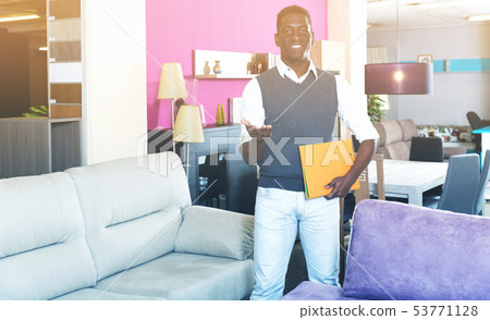 Assistant male in furniture store Assistant male in furniture store 53771128