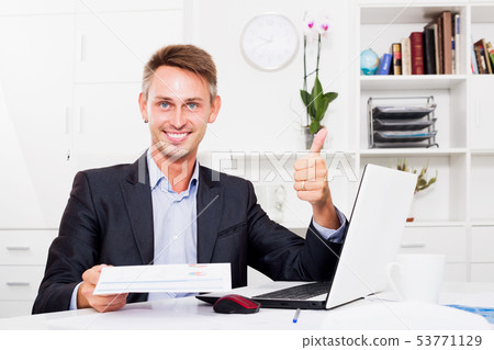 Man sitting with laptop and having paper document 53771129