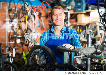 Man working with bicycles wheels 53771150