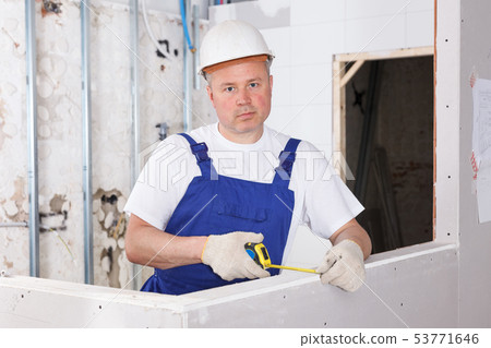 Builder measuring drywall construction Builder measuring drywall construction 53771646