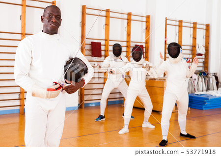 African american male fencer in uniform standing with mask and foil 53771918