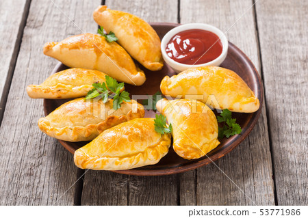 Latin American baked beef empanadas with sauce 53771986