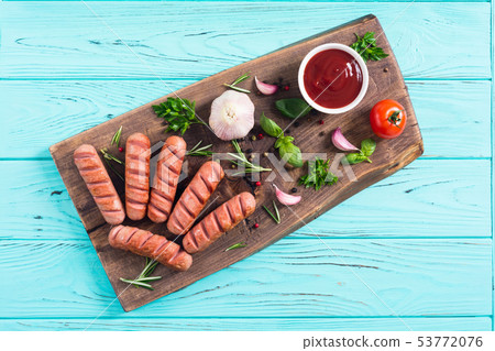 Fried sausages with herbs , spices and ketchup Fried sausages with herbs , spices and ketchup 53772076