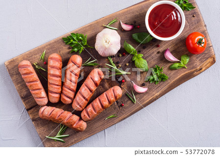 Fried sausages with herbs , spices and ketchup Fried sausages with herbs , spices and ketchup 53772078
