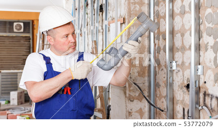 Plumber assembling plastic pipes Plumber assembling plastic pipes 53772079