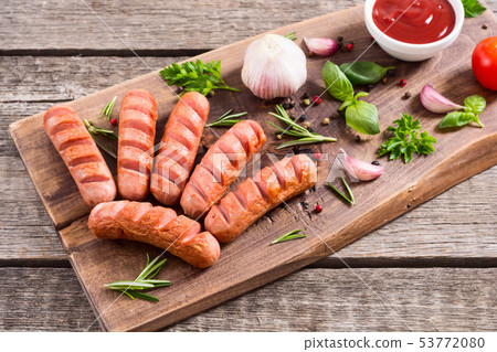 Fried sausages with herbs , spices and ketchup Fried sausages with herbs , spices and ketchup 53772080