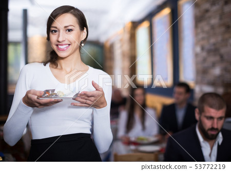 smiling female waitress standing with tray with tips 53772219