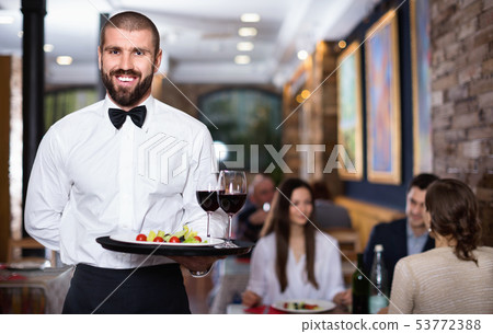 Professional waiter holding serving tray for restaurant guests 53772388