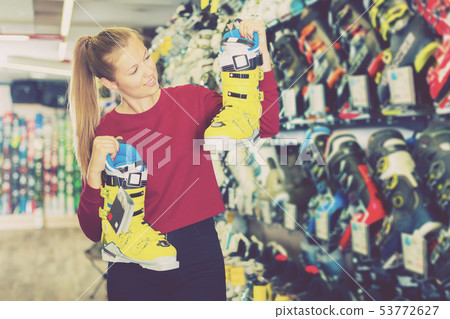 woman is choosing colorful boots for skiing woman is choosing colorful boots for skiing 53772627