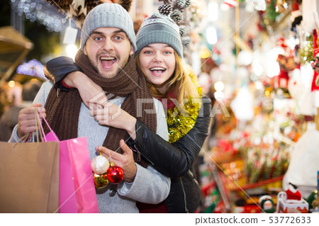 Young couple in hat expression happinnes at Christmas fair Young couple in hat expression happinnes at Christmas fair 53772633