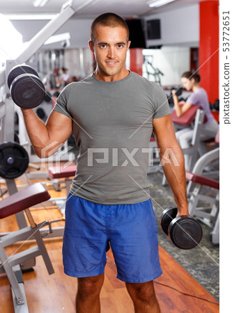 Man doing exercises with sports dumbbells Man doing exercises with sports dumbbells 53772651